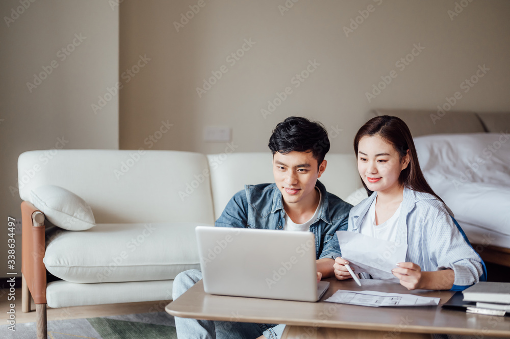 Young Asian couple at home using computer Young Asian couple at home using computer