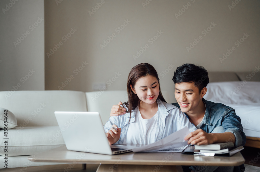 Young Asian couple at home using computer Young Asian couple at home using computer