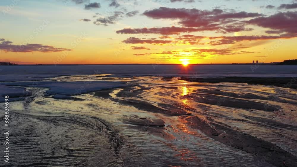 Flying over frozen sea at amazing sunset with red sun and clouds Flying over frozen sea at amazing sunset with red sun and clouds