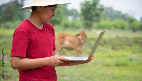 Farmer using laptop in farmland with conection network.