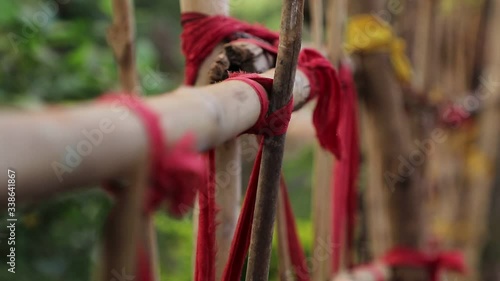 Handcrafted bamboo wood fence with colored rope to hold it in a village / house. Focus racking of fence wood showcasing how long the fence wood. photo