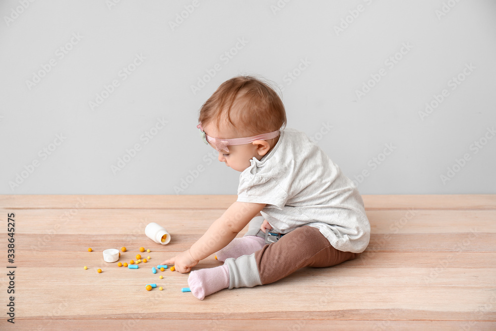 Little baby with medicines on grey background. Child in danger Little baby with medicines on grey background. Child in danger