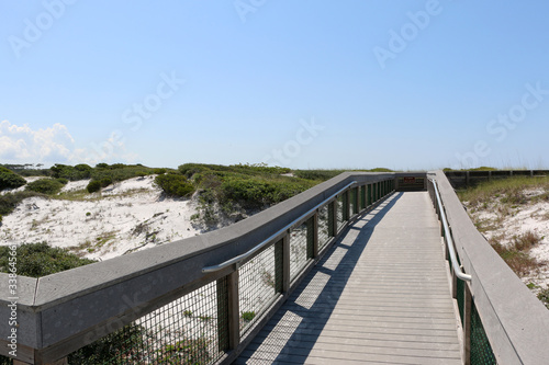 beach boardwalk over sand dunes with blue sky background at santa rosa florida state park  © lightrapture