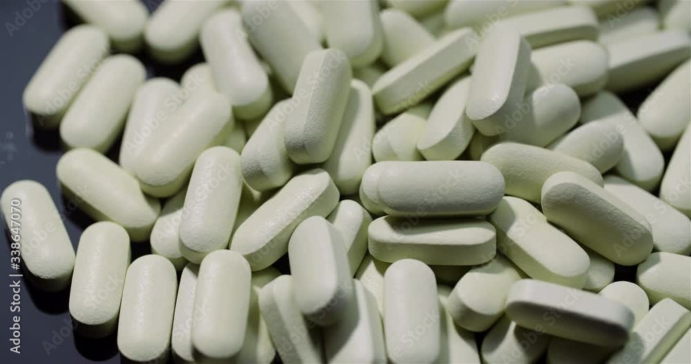 Medical tablets and pills rotating, pharmaceutical industry. Drugs Pills Isolated Black Background. Medical tablets and pills rotating, pharmaceutical industry. Drugs Pills Isolated Black Background.