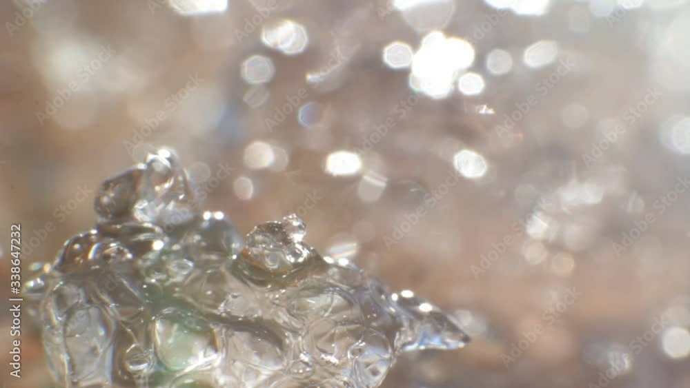 Macro of a piece of ice melting on the spring sun changing state