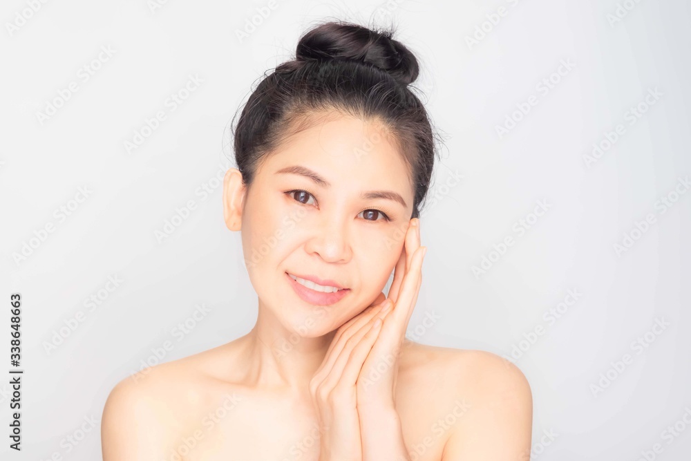 young beautiful asian woman with clean and bright skin, Cosmetic Beauty Concept,hands touch on the cheek, smiling and friendly face isolated on grey background young beautiful asian woman with clean and bright skin, Cosmetic Beauty Concept,hands touch on the cheek, smiling and friendly face isolated on grey background