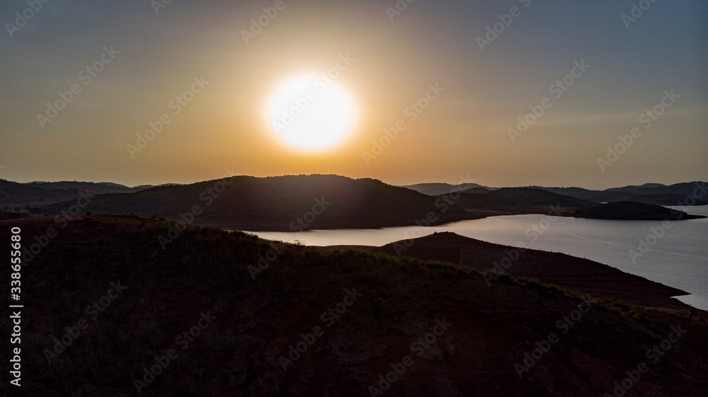 Obraz premium Sun setting over a lake in the mountains