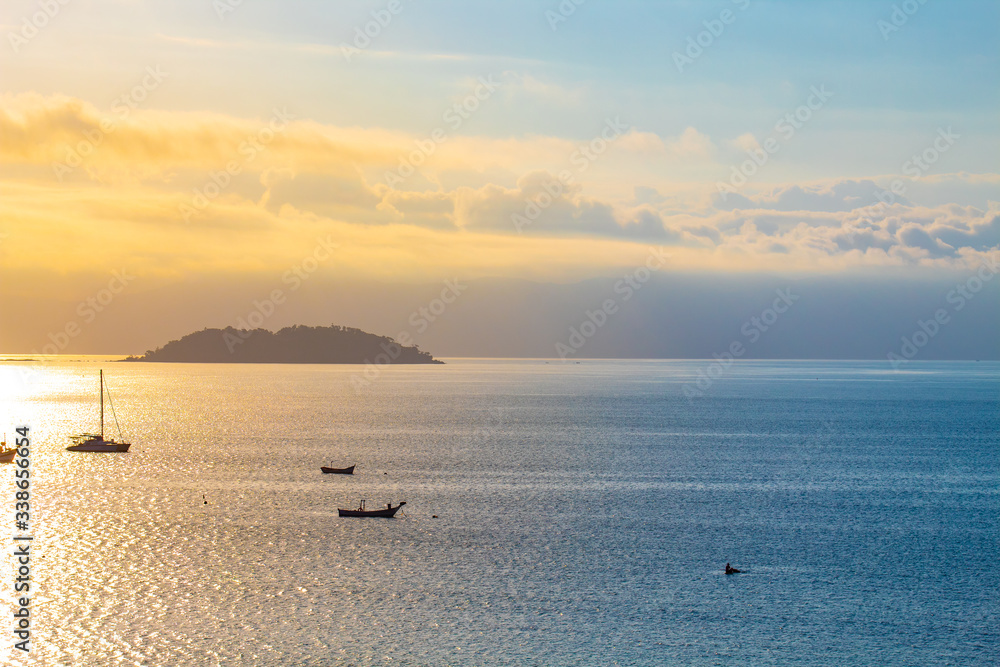 Pôr-do-sol no mar e ilha vista da praia da Cachoeira do Bom Jesus em Florianópolis, SC, Brasil