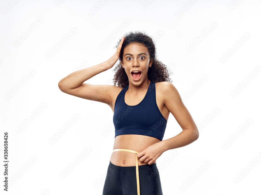 young woman measuring her waist young woman measuring her waist