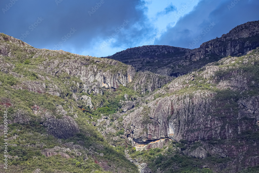 Impressive mountain scenery in sunlight with blue sky and dark clouds of Caraca natural park, Minas Gerais, Brazil
