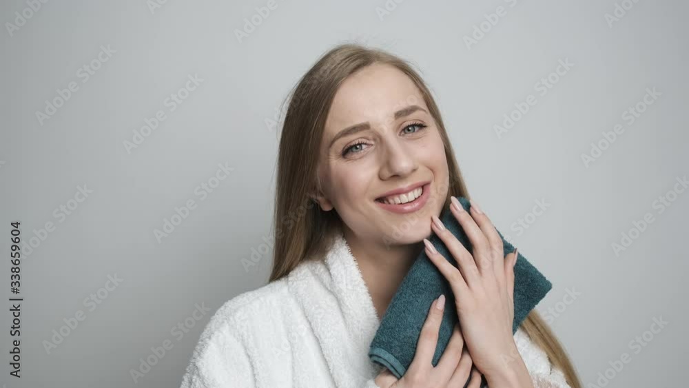 Beautiful girl after the bath wipes her face with a towel Beautiful girl after the bath wipes her face with a towel