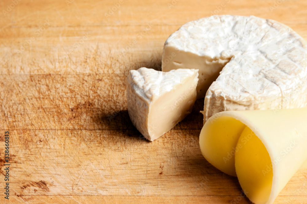 Brie. Cheese cubes that are sliced out on the wooden floor.