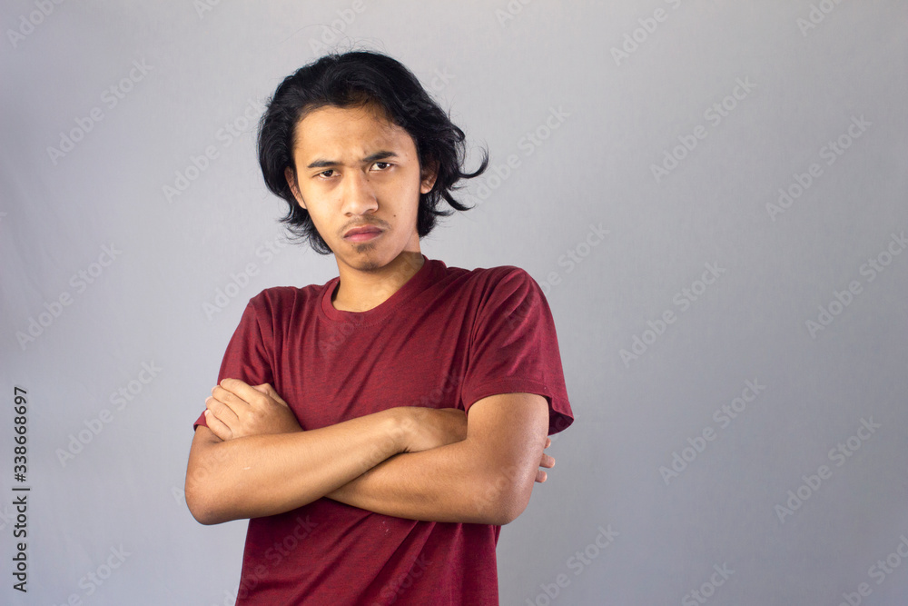 Fototapeta premium Angry little asian teen showing frustration and disagreement, isolated on white background. 