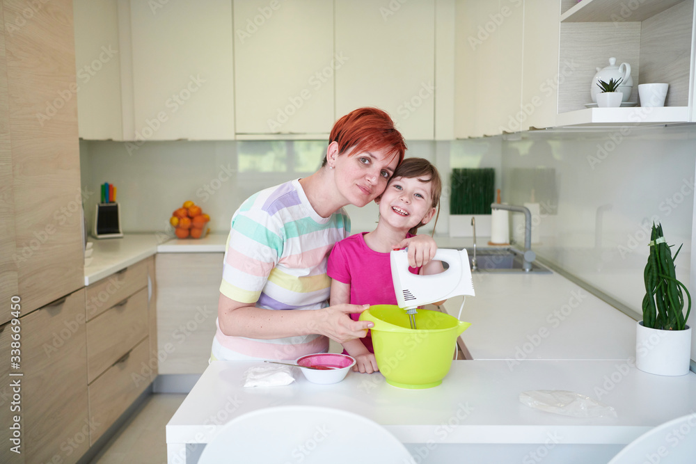 Mother and daughter playing and preparing dough in the kitchen. Mother and daughter playing and preparing dough in the kitchen.