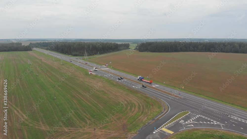 A truck for transporting vehicles moves along the highway. Aero video shooting. A truck for transporting vehicles moves along the highway. Aero video shooting.