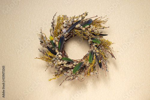 A wreath of dried twigs and flowers on a pastel background. Natural decoration. Celebration concept. Easter wreath. Willow round frame. Flat lay