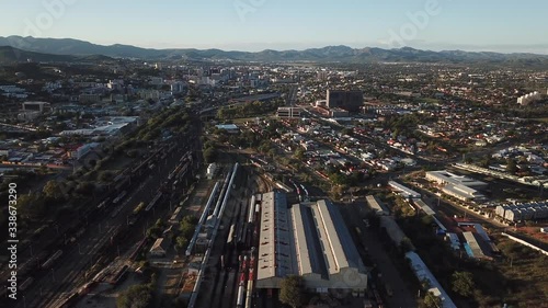 4K aerial Windhoek capital main railway station depot sheds, workshops and railway lines with trains parked area at bright sunrise drone video in Khomas Region, central Namibia photo