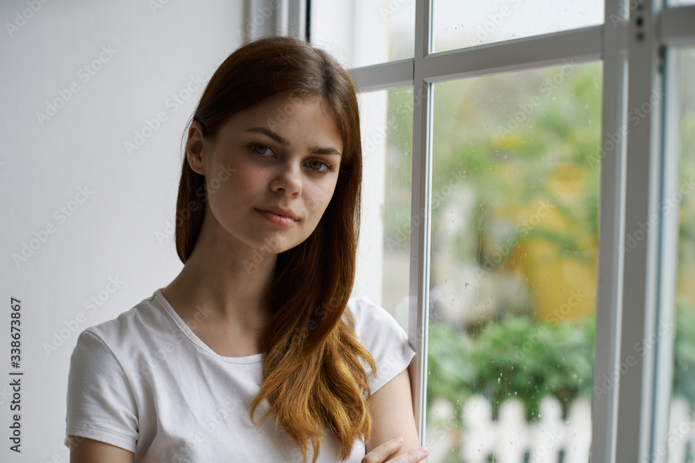 portrait of a young woman looking out window portrait of a young woman looking out window