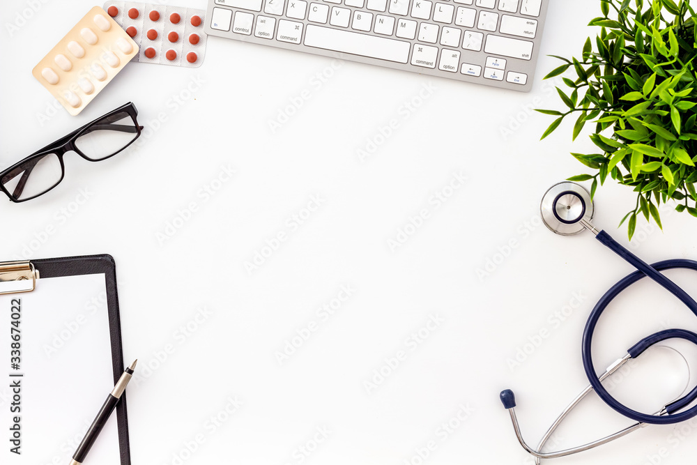 Doctor office desk with medicine and tablet. White table top view copy space