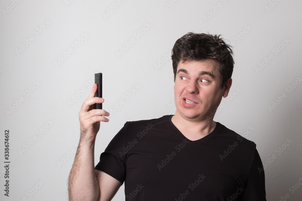Emotional man talking on a cell phone. Caucasian young man screaming on the phone. Emotional man talking on a cell phone. Caucasian young man screaming on the phone.