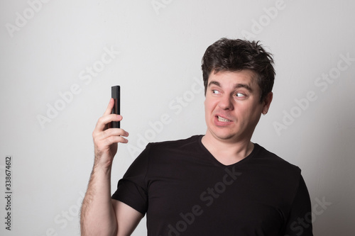 Emotional man talking on a cell phone. Caucasian young man screaming on the phone. © Eugene