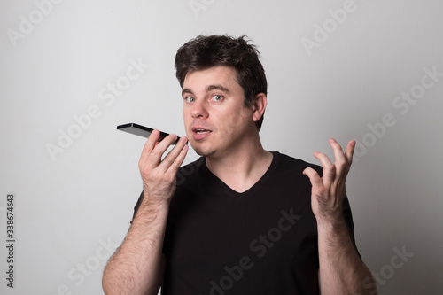 Emotional man talking on a cell phone. Caucasian young man screaming on the phone.