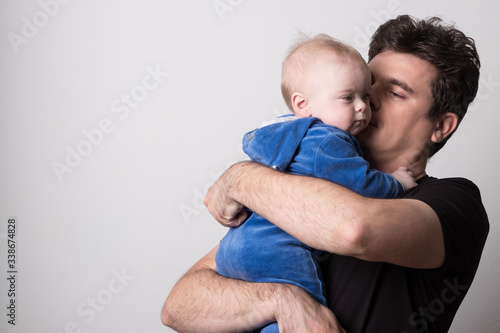 Young dad with a baby. Selective focus. Cute dad is played with a baby.