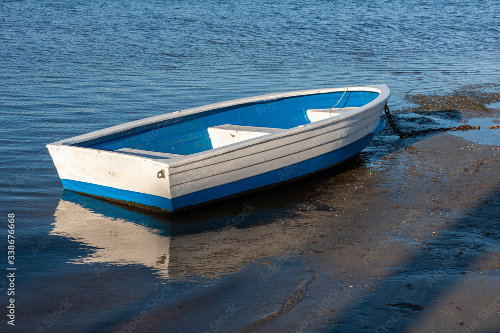 Dinghy beached by the tide on Knysna lagoon Dinghy beached by the tide on Knysna lagoon