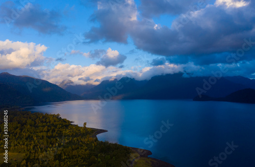 aerial view of Lake Chapo surrounded by mountains covered with native forest