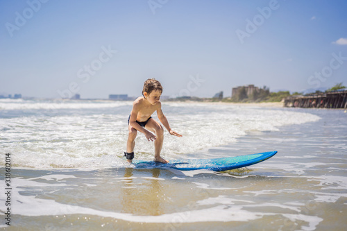 Healthy young boy learning to surf in the sea or ocean © galitskaya