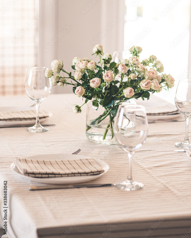 Fototapeta premium served table with a vase with light roses
