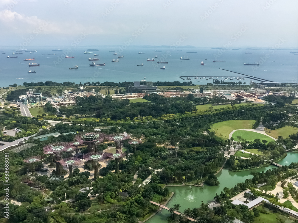 Singapore. Aerial view from the pool of the famous Marina Bay Sand hotel. Gardens by the Bay is a beautiful nature park in the Central Region of Singapore. Supertrees, 18 tree shape structures. 