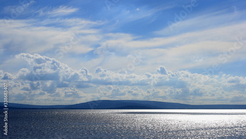Fototapeta Naklejka Na Ścianę i Meble -  shimmering ocean waters, shispy clouds, blue skyGalway bay, Galway, Ireland, ocean landscape