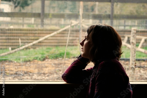 Silhouette of woman gazing out of window