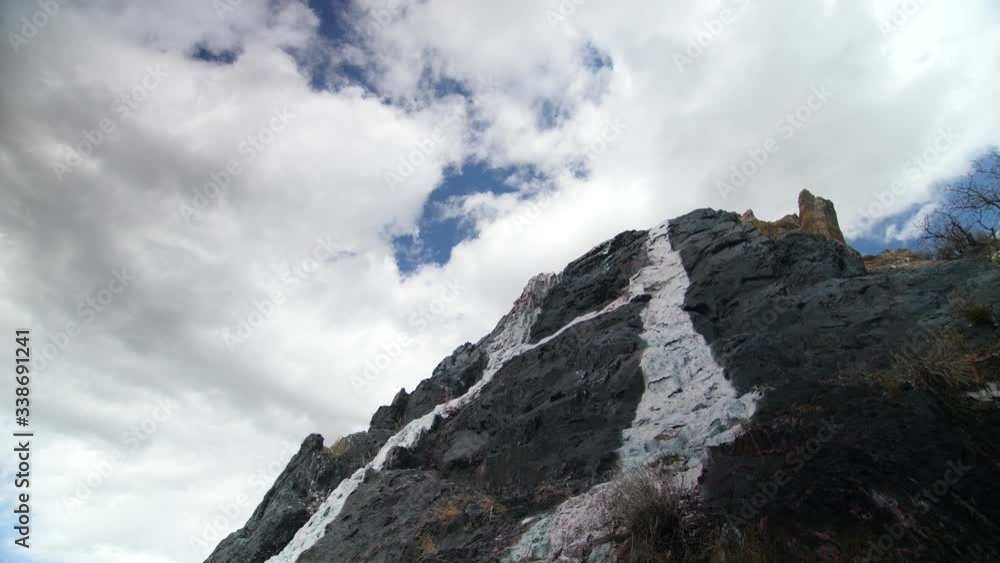 Shot looking up spray painted rock outcropping at cloudy blue sky. Shot looking up spray painted rock outcropping at cloudy blue sky.