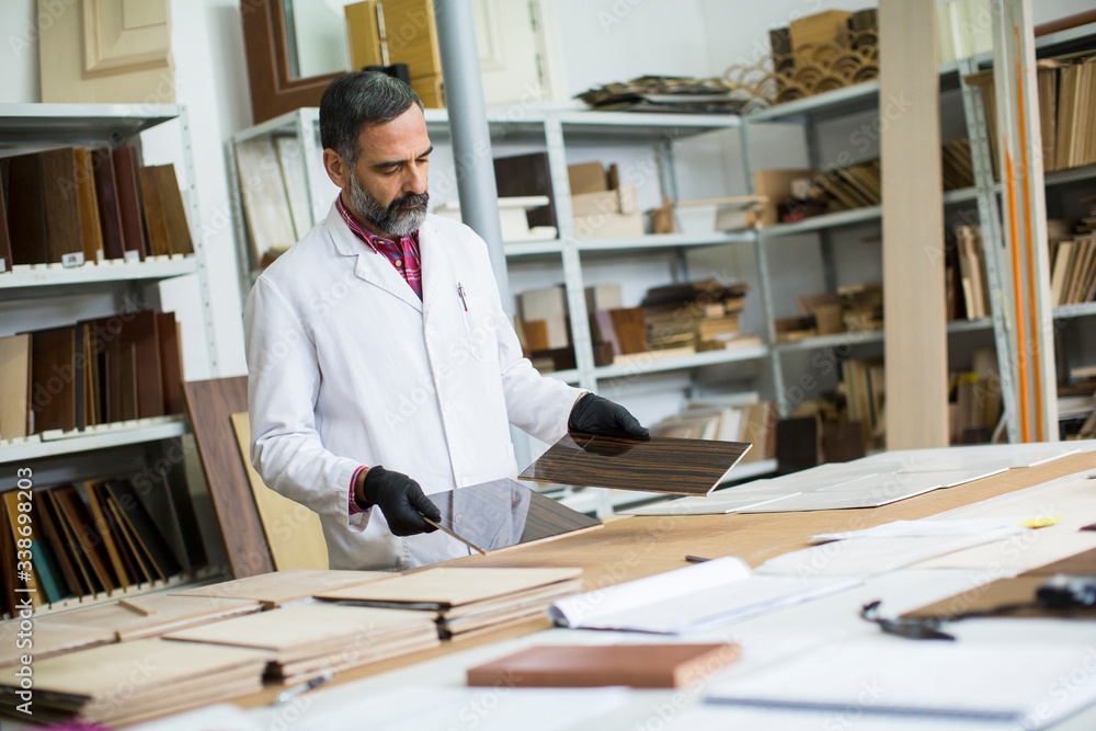 Handsome mature engineer in the laboratory examines ceramic tiles Handsome mature engineer in the laboratory examines ceramic tiles