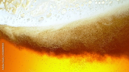 Super Slow Motion Detail Shot of Rippling Beer Bubbles and Foam in Glass at 1000fps. photo