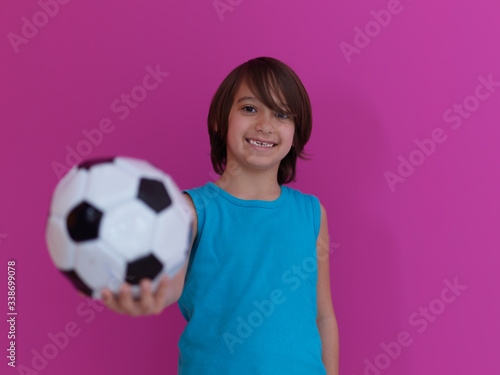 Arabic boy with soccer ball against pink background