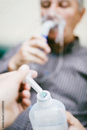 Preparation of compressor nebulizer for use on senior man with respiratory mask  nebulizer