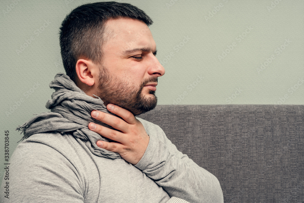 Obraz premium Disease. Cheer at home. A young man is sick, is treated at home. Blows her nose into a napkin, runny nose. Infection, epidemic, bacillus carrier.