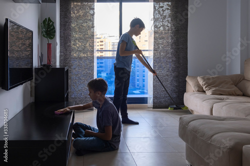 Children sweeping floor and cleaning dust in living room at home. Housekeeping and household