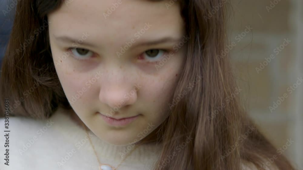 Sweet teenage girl looks up at camera with big brown eyes and a sad face, close up. Sweet teenage girl looks up at camera with big brown eyes and a sad face, close up.