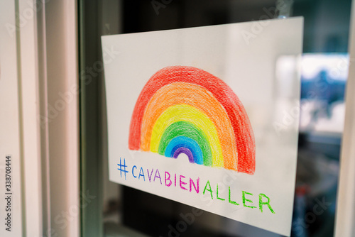 Covid-19 Rainbow window drawing to spread positivity in community for coronavirus stay home self isolation with hashtag #cavabienaller, ca va bien aller social media sharing. Kids drawing. photo