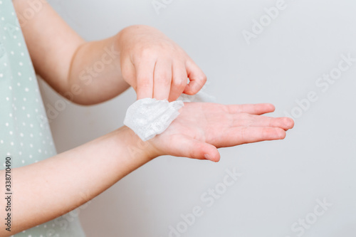 The child wipes her hands wet antibacterial wipe.