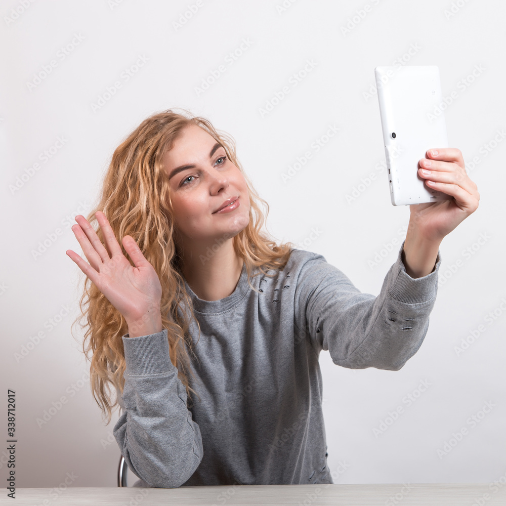 The girl holds tablet, talking by video link. The concept of remote communication. The girl holds tablet, talking by video link. The concept of remote communication.