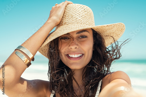 Happy woman wearing straw hat at summer beach