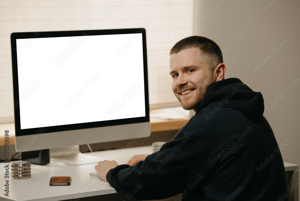 Remote work. A businessman works remotely using an all-in-one computer. A smiling fellow working from home. Remote work. A businessman works remotely using an all-in-one computer. A smiling fellow working from home.