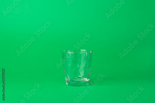 and empty faceted glass on a green background
