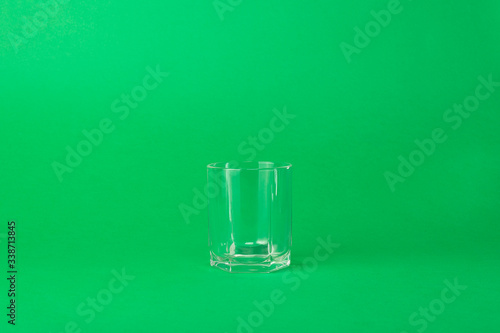 and empty faceted glass on a green background