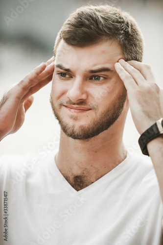 smiling friendly guy with a variety of emotions; a man in a white T-shirt and jeans with a clock on his hand;